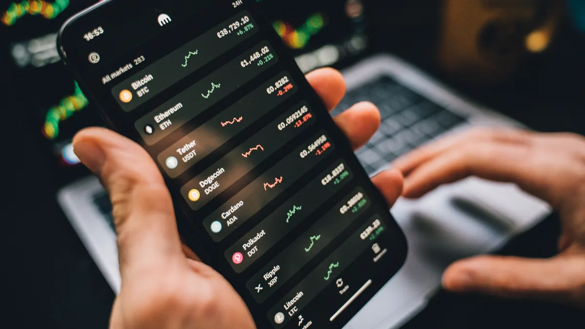 Smartphone with trading app interface and market charts