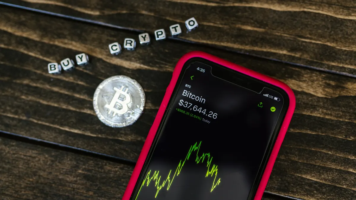 smartphone with Bitcoin chart and 'buy crypto' text