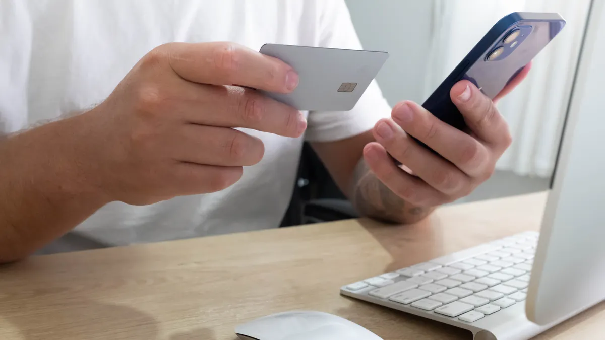 How to Keep Crypto Safe from Scams and Theft person comparing a card and smartphone beside laptop